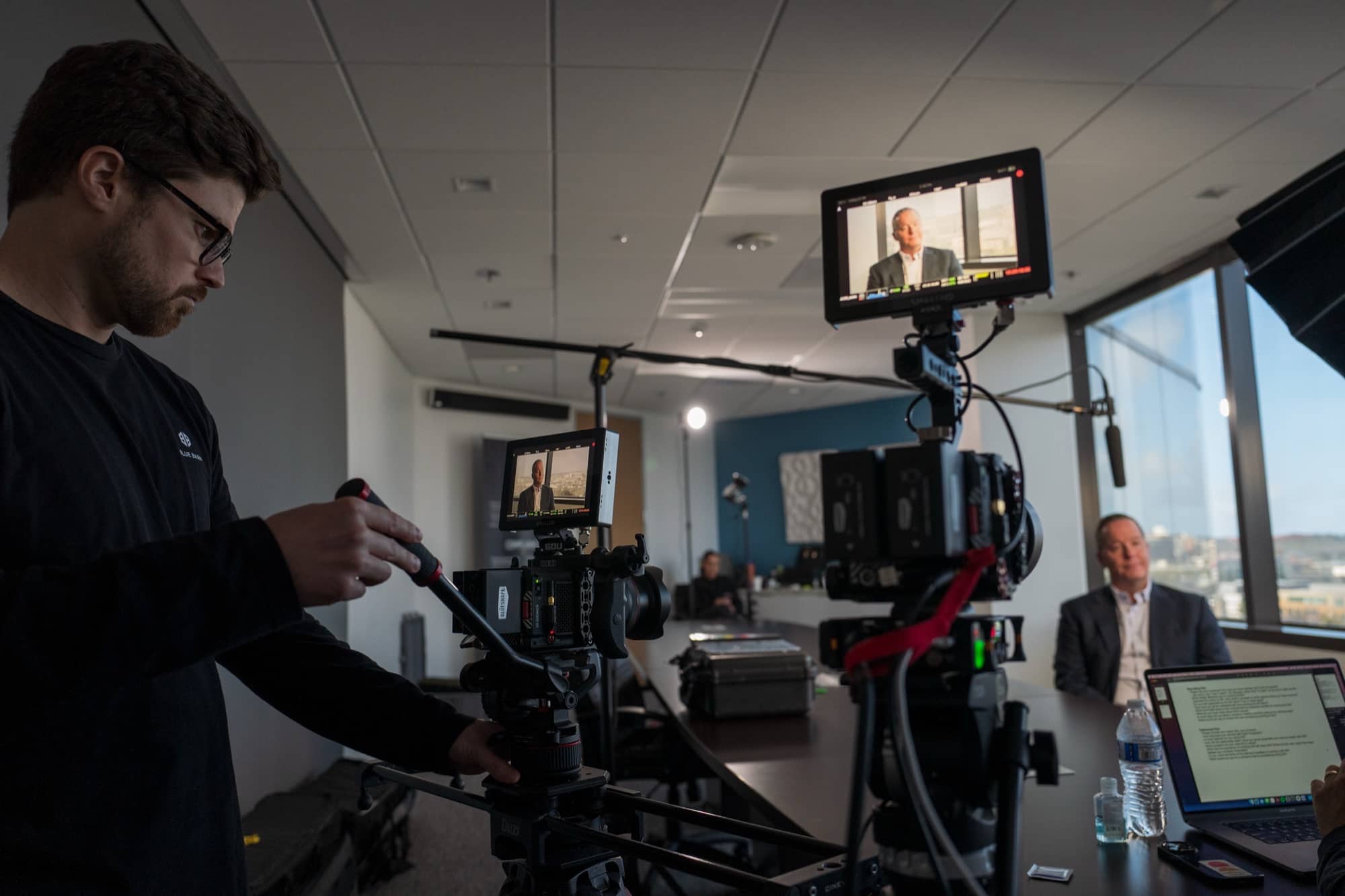 Blue Barn videographer filming an executive interview in a corporate conference room
