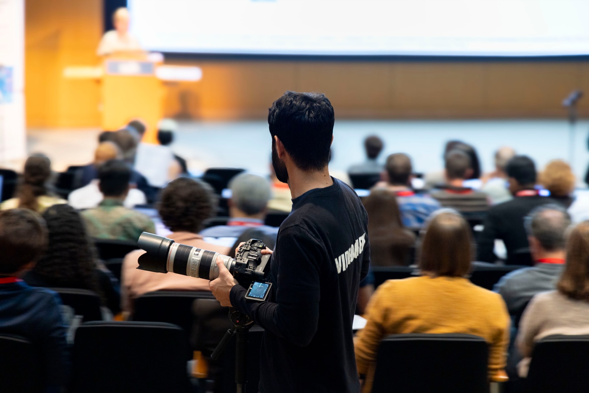 Blue Barn videographer filming a keynote presentation from the back of a conference auditorium