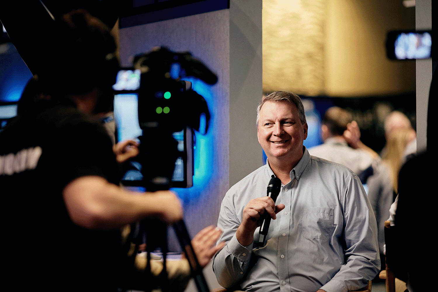 Conference interviewee smiling with a lavalier microphone clipped on