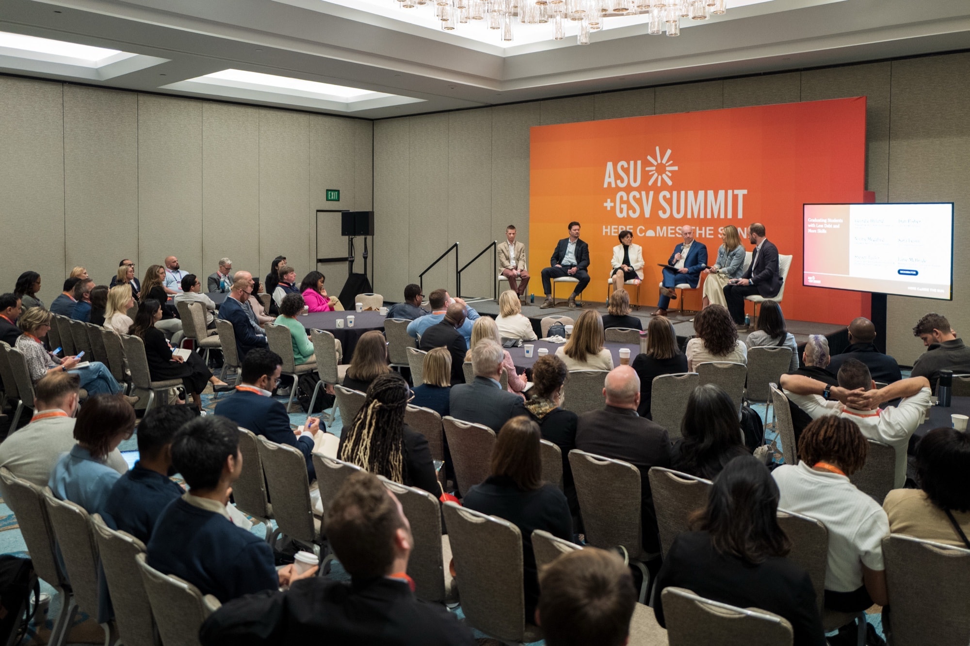Wide shot of an ASU+GSV Summit seminar — engaged audience and panel of speakers on stage